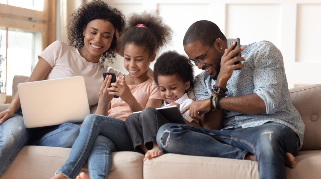 A happy family on their devices at home