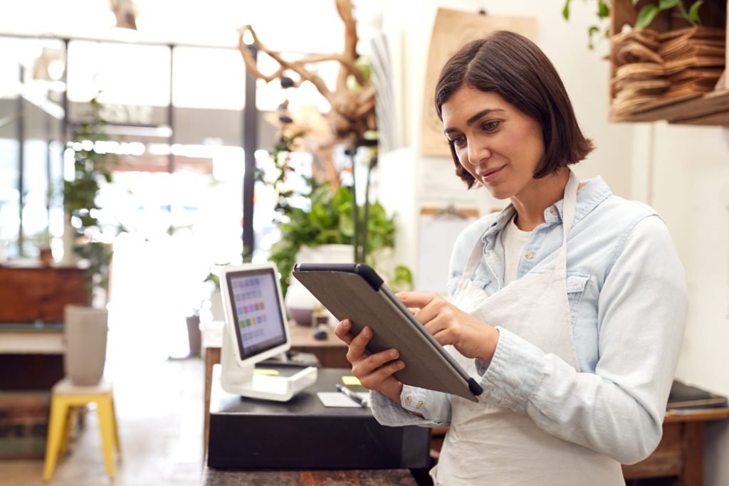 A business owner in her retail store on her iPad