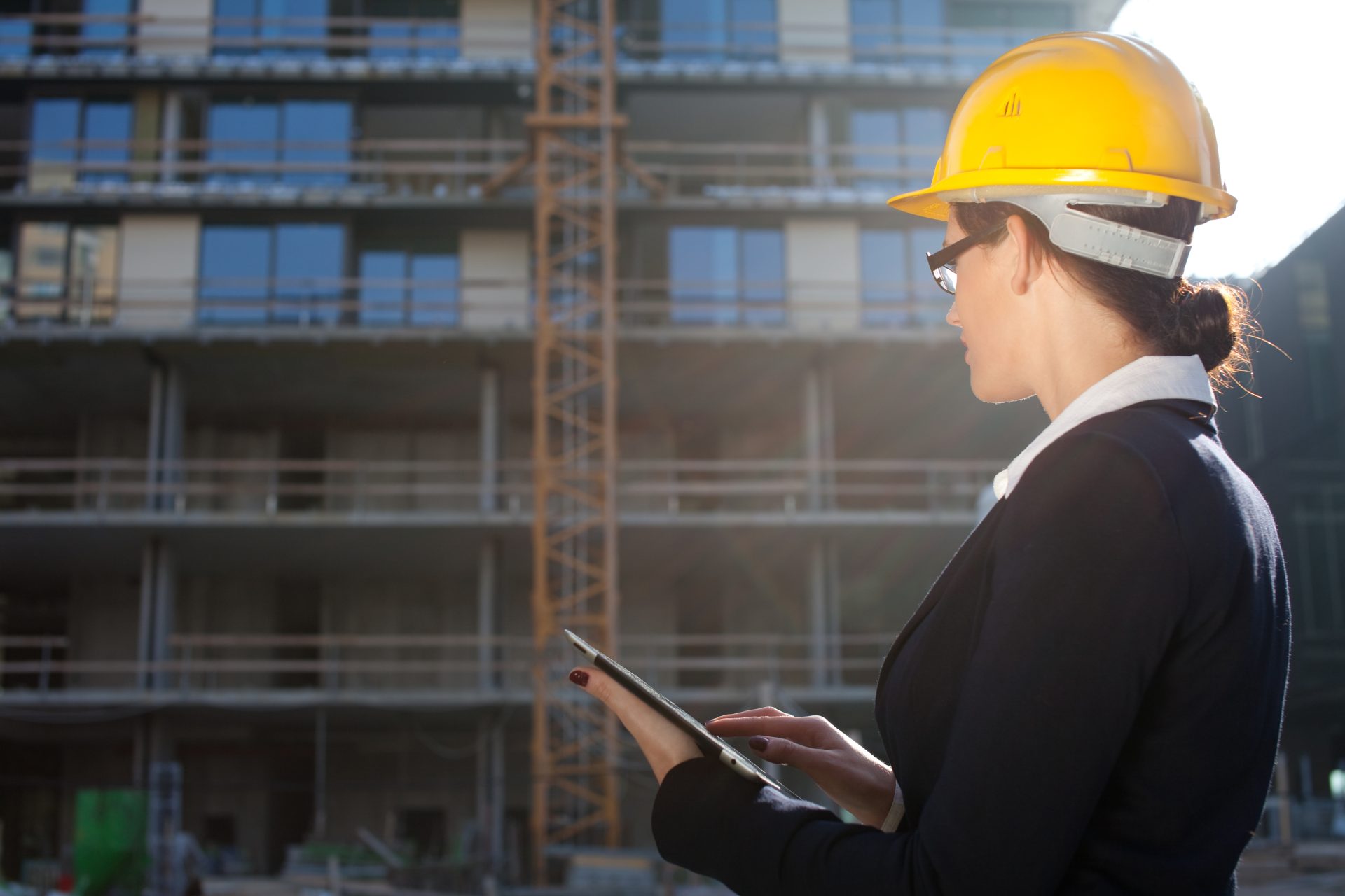 Construction woman with a clipboard and hardhat on a construction site